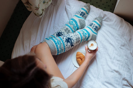 A young beautiful woman in warm handmade knitted clothes at home. . spring, winter season. Gaiters....