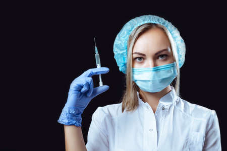Portrait of a girl doctor on a black background in glasses for vision and glovesの写真素材