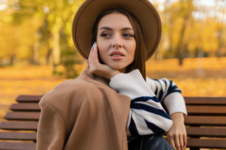 portrait of attractive stylish smiling portrait of attractive stylish smiling woman with long hair walking in the park, dressed in warm brown coat autumn trendy fashion, street style wearing hatの写真素材