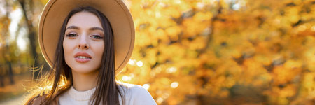 Cheerful beaut Happy smiling young woman in the park on a sunny autumn day.の写真素材