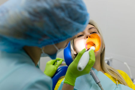 Medicine, dentistry and healthcare concept, dentist using dental curing UV lamp on teeth of patient.の写真素材