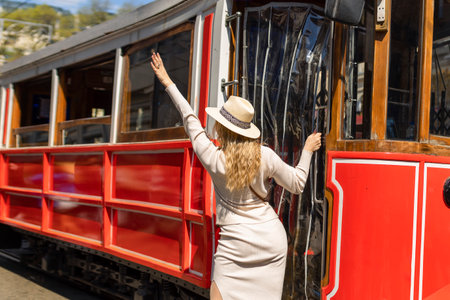Beautiful young girl tourist in a hat poses in front of tram at popular Istiklal street in Beyoglu, Istanbul, Turkeyの写真素材