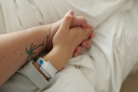 Husband holding womans hand in hospitalの写真素材