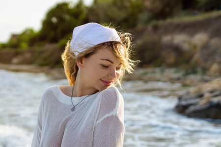 Beach woman in trendy beachwear. caucasian tourist girl in white pareo for sun protection, relaxing walk in ocean water during summer holidays.の写真素材