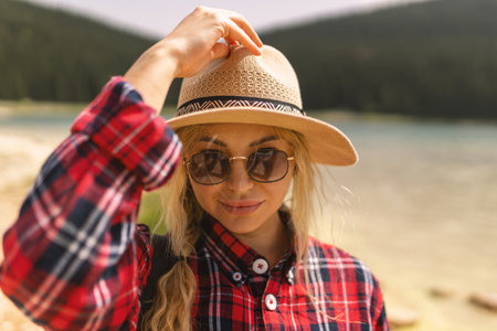 Woman traveler wearing hat and looking at amazing mountains and lake, wanderlust travel concept. black lake Montenegro.の写真素材