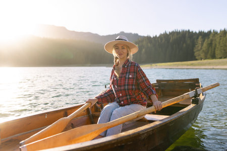 Portrait of a young woman rowing a boat on a spring day in Durmitor National Park in Montenegro