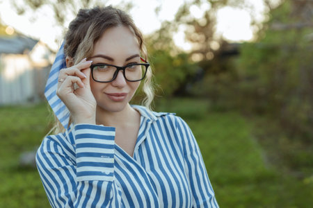 A girl looks at the camera on her glasses. Beautiful look through the frames close-upの写真素材