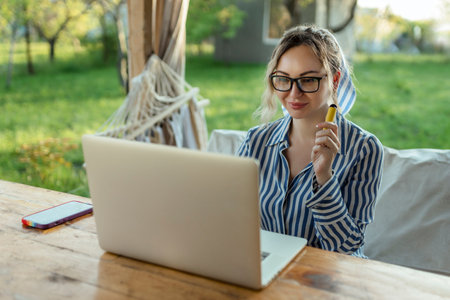 freelance girl works at a computer outside the houseの写真素材