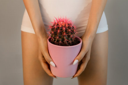 The concept of hair removal, smoothness. A woman with an orange cactus in her hands in underwear.の写真素材
