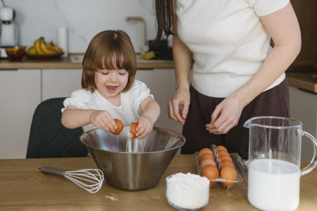 Mother and little daughter baking together in modern kitchen at home, happy family cooking and...