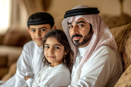 Happy Arab fam ily with little son sitting on sofa in living room Generative AIの素材