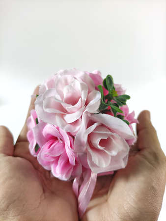Hands holding a mini rose bouquet with white backgroundの写真素材