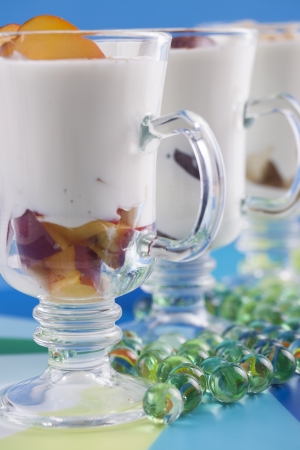 Home made natural fruits yogurt in a tall glass with peach, red grapes and bananaの写真素材