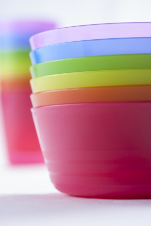 Colorful plastic cups and bowls over a solid bright backgroundの写真素材