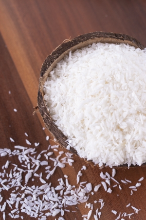 Coconut and coconut flakes over a dark brown wooden backgroundの写真素材