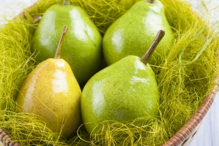 Close up photo of edible fruits - a pears on a solid  bright blue wooden tableの写真素材
