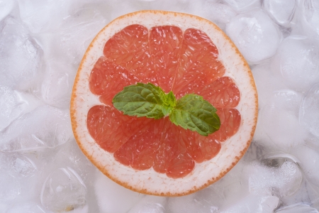 Composition of fresh red grapefruit slices with ice cubes and mint herb leaf.の写真素材