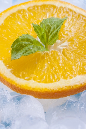 Composition of fresh orange fruit slices with ice cubes and mint herb leafs の写真素材