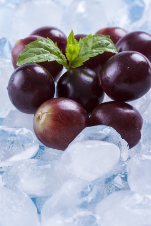 Composition of red grapes fruit slices with ice cubes and mint herb leafs.の写真素材