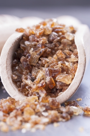 Close up photo of caramelized sugar in a spatula on a dark solid wooden background.の写真素材