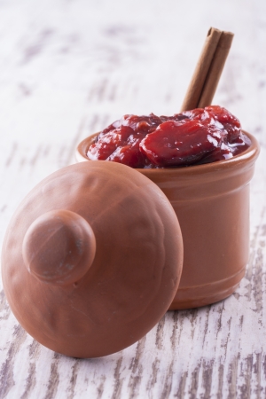 A close up photo of sweet fruits dessert - plum jam, also known as plum powidl in a clay cup.の写真素材