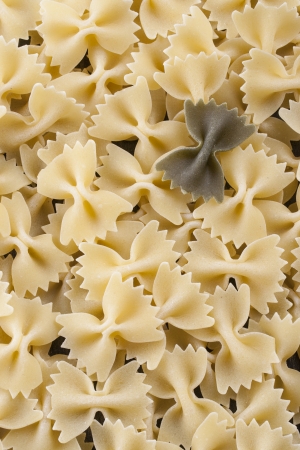 Raw food composition - yellow and green farfalle pasta on a dark background.の写真素材