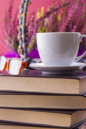 Autumn style close up photo of a hot coffee cup placed on the top of a books.の写真素材
