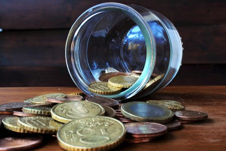 coins falling from the glass bottleの写真素材