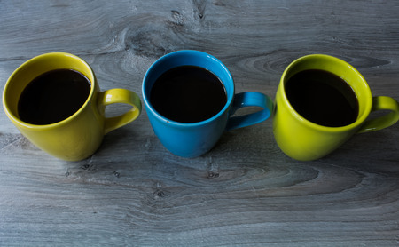 a three cup different color on the wooden gray backgroundの写真素材