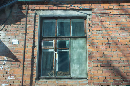 Old window on the brick wall of an old building in Russia.