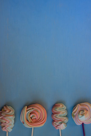 Colorful lollipops on blue wooden background. Top view.の写真素材