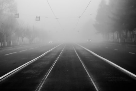 Railway tracks in the fog. Black and white photo. Blurred background.の写真素材