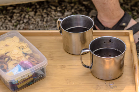 Coffee in a metal mug on a wooden table, selective focus