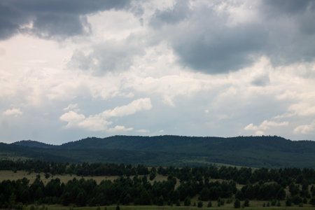 Beautiful summer landscape with blue sky and clouds over the forest.の写真素材