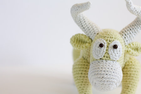 Knitted toy deer on a white background. Knitted animal. unusual knitted toys. background for handicraftsの写真素材