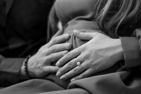 Closeup of the hands of a couple holding each other. Black and white photo.の写真素材