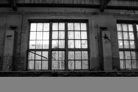Abandoned industrial building with large windows. Black and white photo.の写真素材