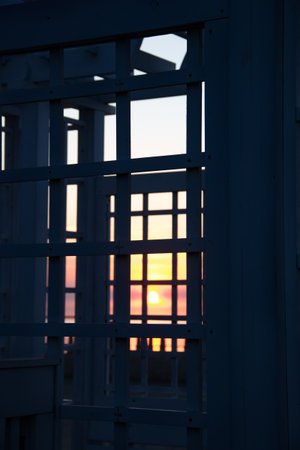 Sunset through the metal lattice of the entranceの写真素材