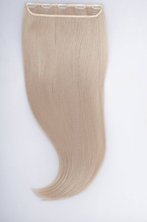 Straight blond remy virgin human hair clip in extensions on light grey backgroundの写真素材