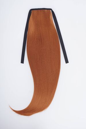 Artificial tail on ribbon. Straight virgin remy human hair clip in extensions on light grey backgroundの写真素材