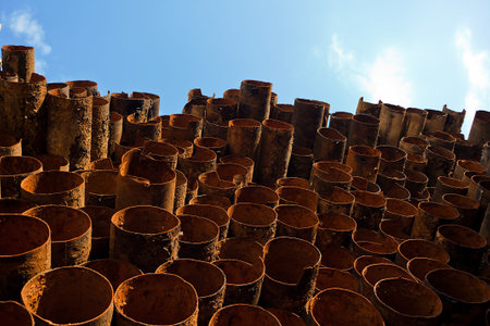 Old rusty pipe dumped in a pileの写真素材