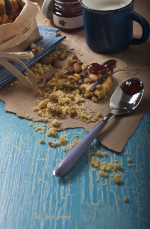 Closeup of a broken peanut biscuit and spoon  with jam on blue craquelure background の写真素材