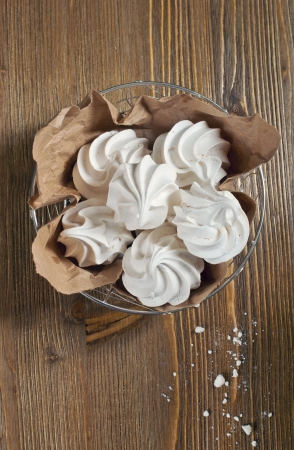 Closeup top view of lot of meringues in iron bowl on dark wooden backgroundの写真素材
