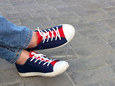 Feet sneakers in the park on the benchの写真素材