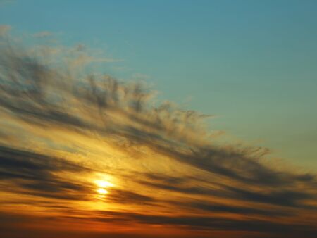 The sun goes down. Beautiful fan of gray cloudsの写真素材