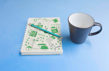 still life with notebook , pencil and cup of coffee on Blue backgroundの写真素材