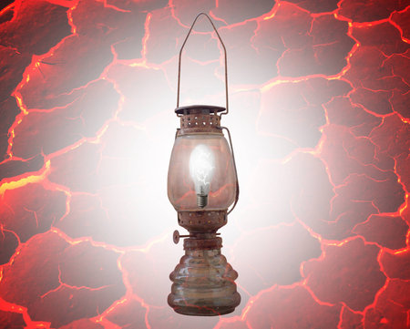 Old dusty rusty oil lamp with a light bulb inside. isolated on redの写真素材