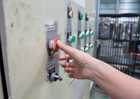 Male hand pushing emergency red stop button on a white background.Blur Picture
