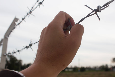 Man handles barbed wire without the individual freedom life. Wait for release