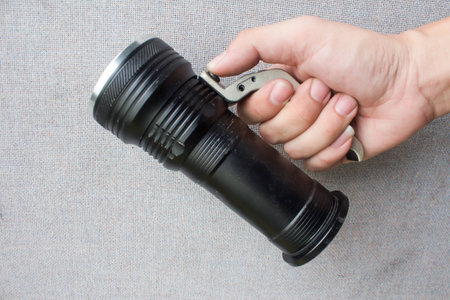 Mens hand holding a flashlight on backgroundの写真素材